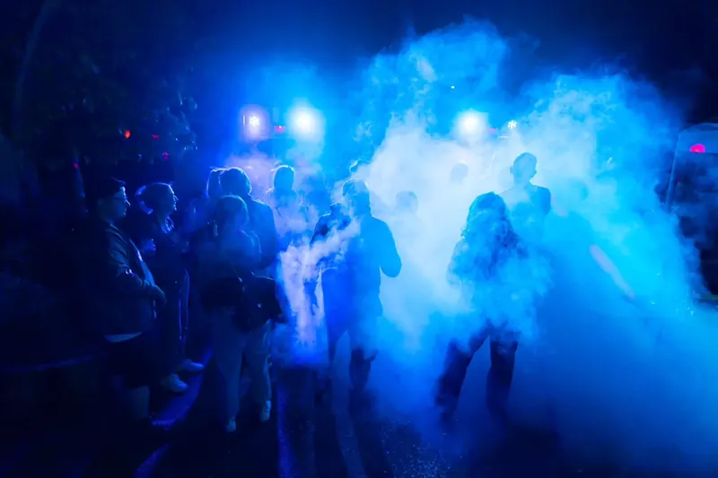 Tanzende Gäste im blauen Bühnenlicht