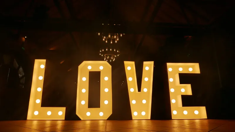 Warmweiß leuchtende LOVE-Buchstaben in einer Eventlocation