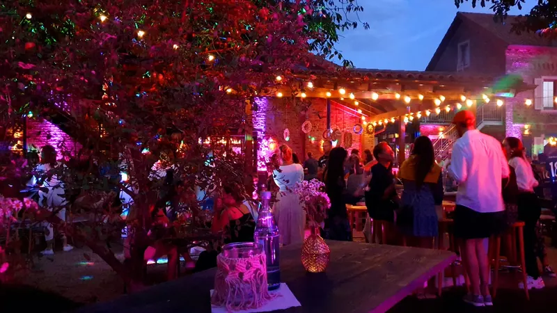 Sommerabend mit Gästen und Lichterketten im Innenhof