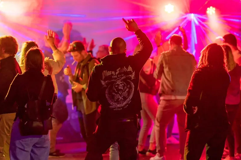 Gäste tanzen im warmen Licht auf einer Party